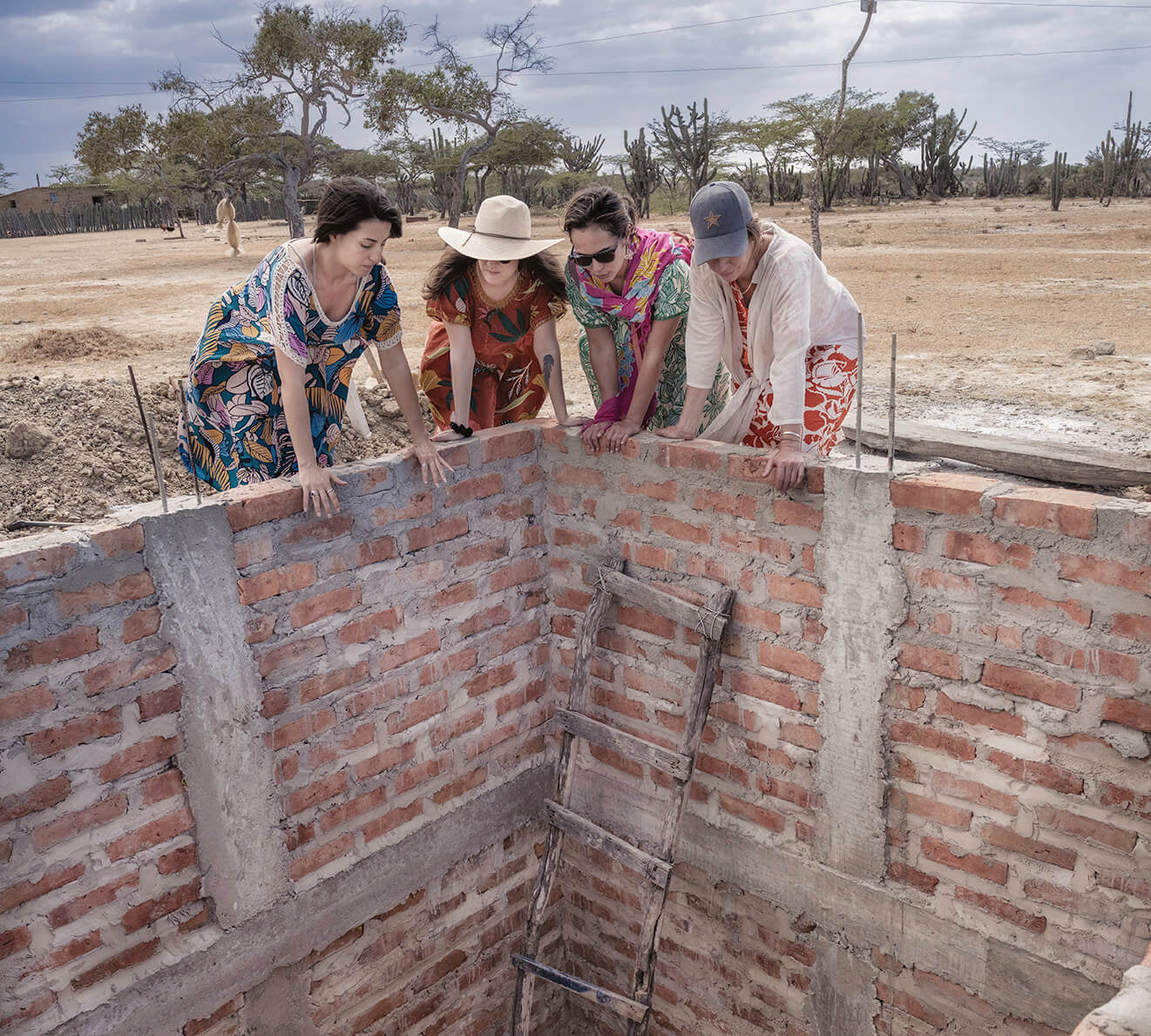 Group of people working looking into a water well.